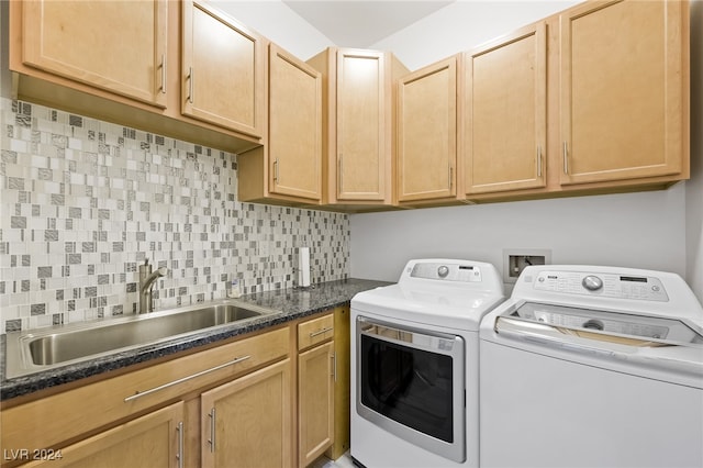 laundry room featuring cabinets, sink, and washing machine and clothes dryer