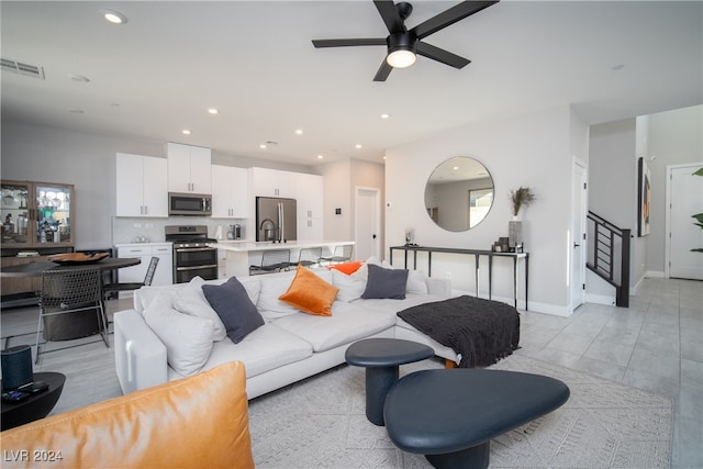 living room featuring ceiling fan and sink