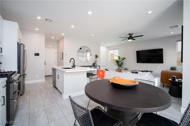 tiled dining space with ceiling fan and sink