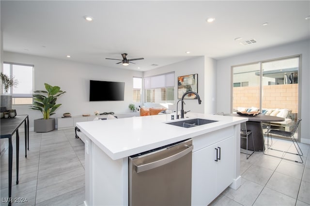 kitchen with dishwasher, a kitchen island with sink, sink, white cabinets, and ceiling fan