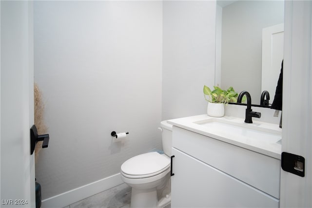 bathroom featuring tile patterned floors, vanity, and toilet