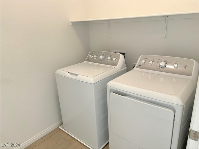 laundry room with light wood-type flooring and separate washer and dryer