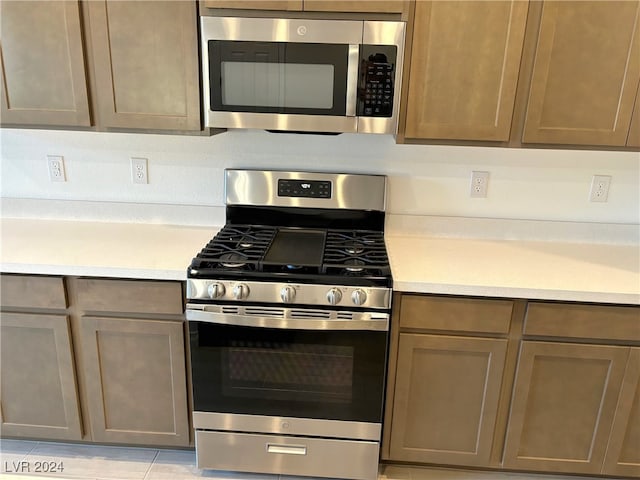 kitchen featuring light tile patterned floors and stainless steel appliances