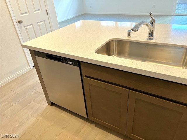 kitchen featuring sink, stainless steel dishwasher, and light wood-type flooring