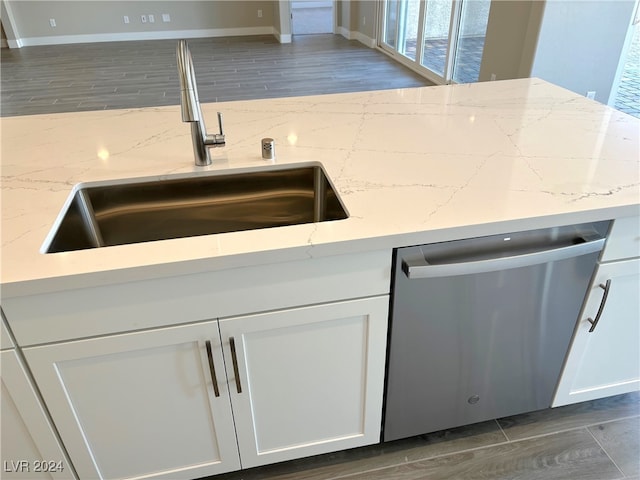 kitchen featuring stainless steel dishwasher, dark hardwood / wood-style floors, white cabinetry, and sink