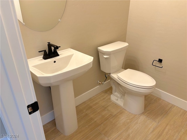 bathroom with toilet and wood-type flooring