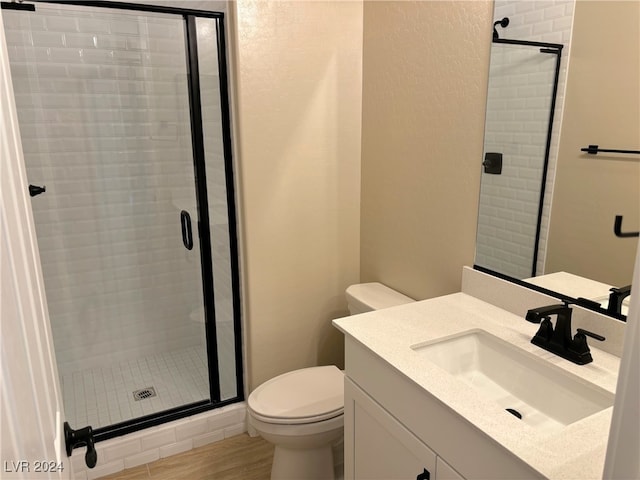 bathroom featuring walk in shower, toilet, vanity, and hardwood / wood-style flooring