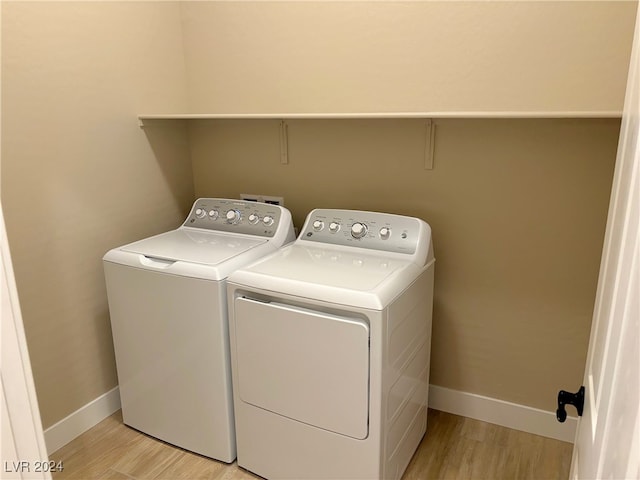 washroom featuring light hardwood / wood-style floors and washer and clothes dryer