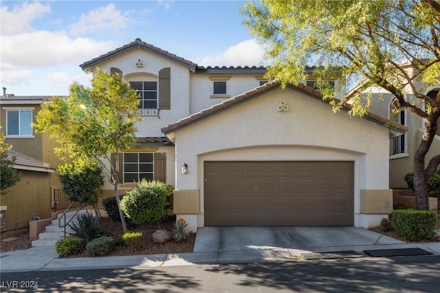 mediterranean / spanish home with a garage