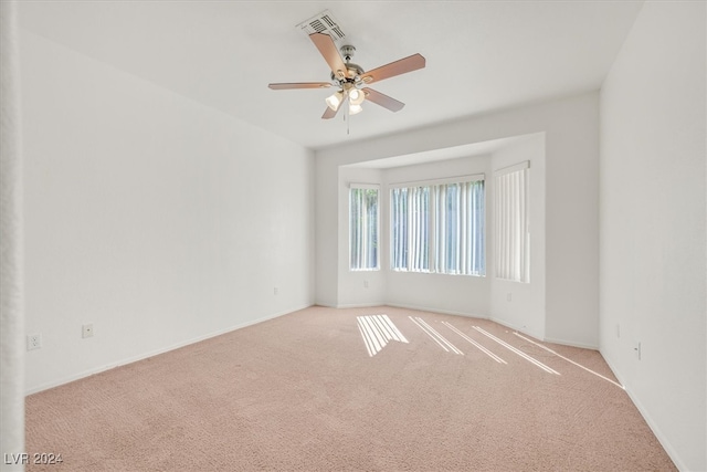 carpeted empty room featuring ceiling fan