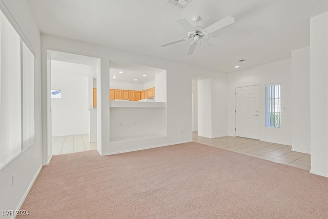 interior space with light carpet and ceiling fan