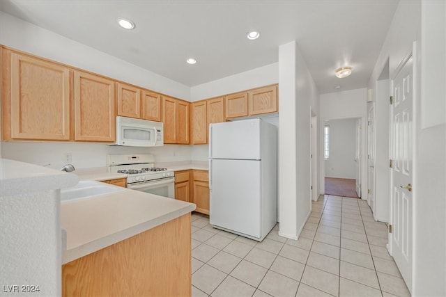 kitchen featuring white appliances, light brown cabinets, light tile patterned floors, and sink