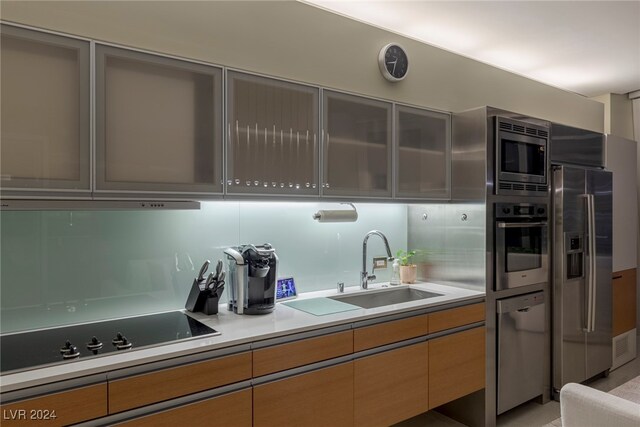 kitchen with appliances with stainless steel finishes, decorative backsplash, and sink