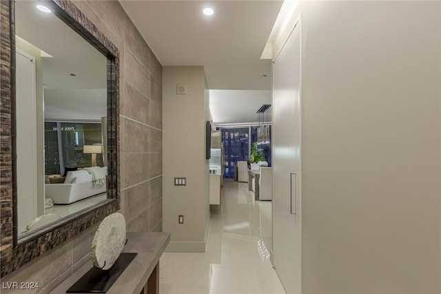 hall featuring tile walls and light tile patterned floors