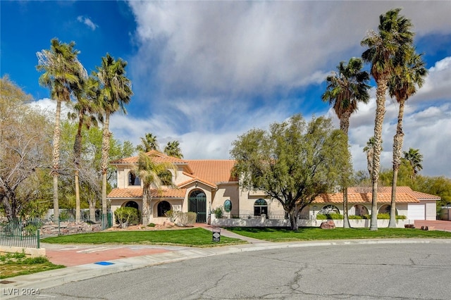 mediterranean / spanish-style house with a garage and a front lawn