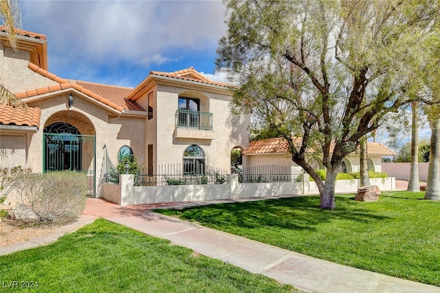 mediterranean / spanish home featuring a balcony and a front yard