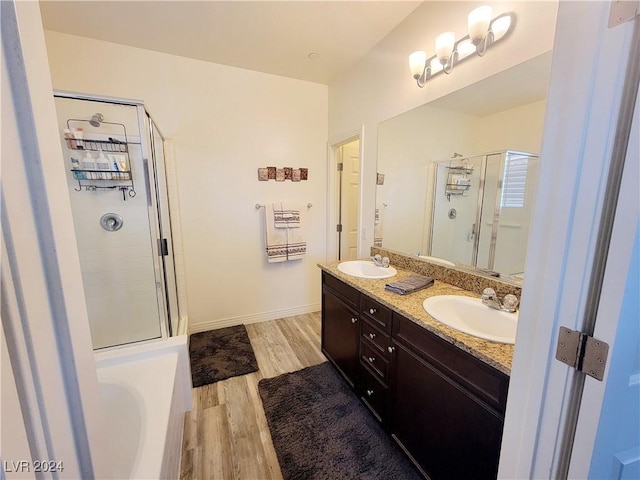 1152 Bear Head St, Henderson, NV 89011 - full bathroom with double vanity, wood finished floors, a sink, a stall shower, and a garden tub