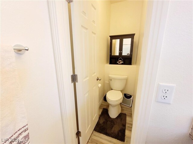 bathroom featuring wood-type flooring and toilet