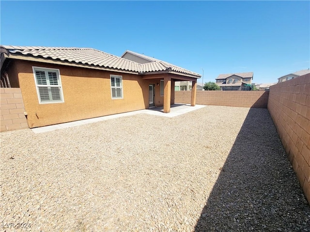 1152 Bear Head St, Henderson, NV 89011 - rear view of house featuring stucco siding, a fenced backyard, a tiled roof, and a patio area