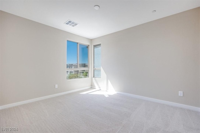 carpeted spare room with baseboards and visible vents