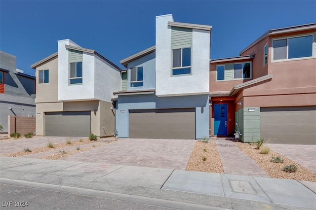 view of front of house with driveway, stucco siding, and an attached garage