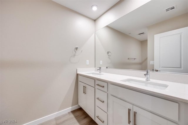 full bathroom featuring baseboards, visible vents, wood finished floors, and a sink