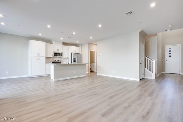 unfurnished living room with light hardwood / wood-style floors and sink