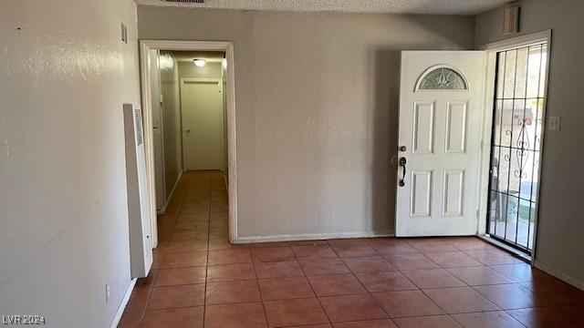 foyer featuring tile patterned flooring and a textured ceiling