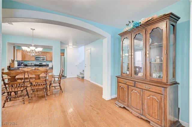 dining area featuring light hardwood / wood-style floors and an inviting chandelier