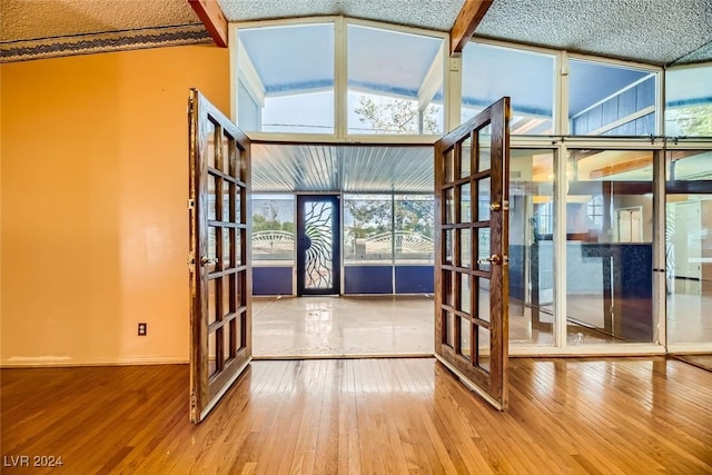 interior space featuring french doors and vaulted ceiling with beams