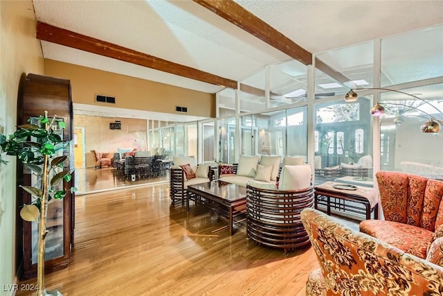 living room with hardwood / wood-style floors and vaulted ceiling with beams