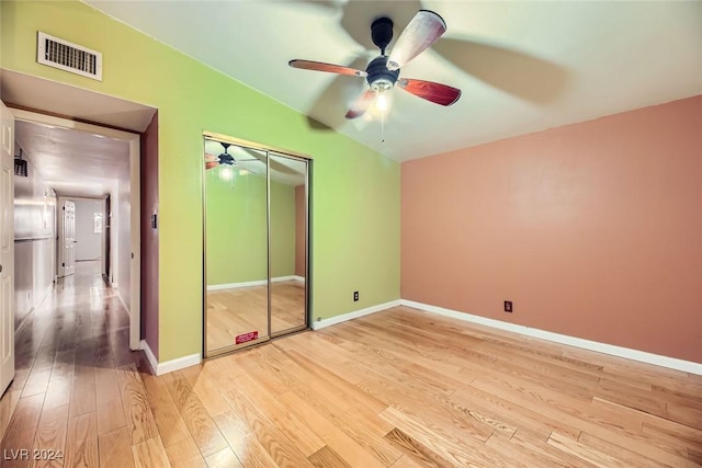 unfurnished bedroom with ceiling fan, a closet, and light hardwood / wood-style flooring