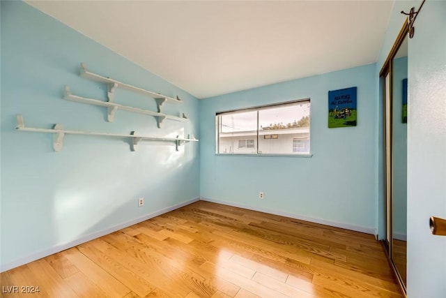 empty room featuring light hardwood / wood-style floors and vaulted ceiling