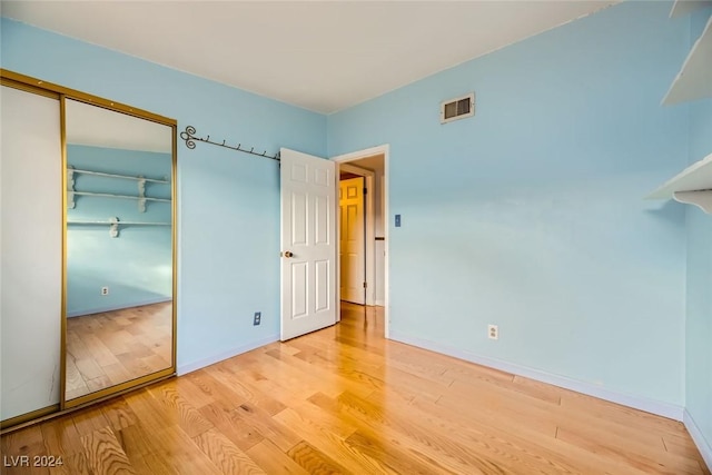 unfurnished bedroom with a closet and wood-type flooring