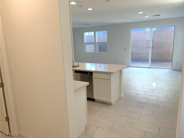 kitchen featuring dishwasher, light tile patterned floors, white cabinetry, and a wealth of natural light