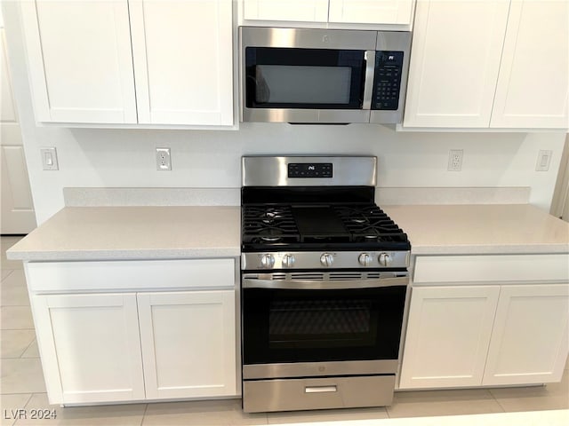 kitchen with white cabinetry, light tile patterned flooring, and stainless steel appliances