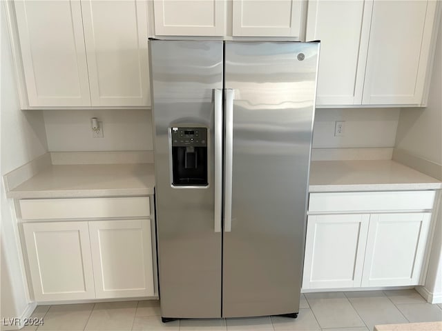 kitchen with white cabinets, light tile patterned floors, and stainless steel refrigerator with ice dispenser