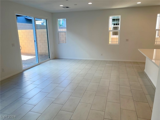 spare room with light tile patterned floors and plenty of natural light