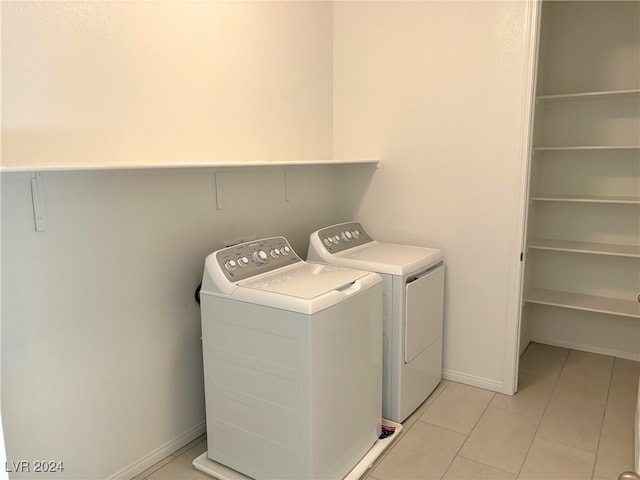 laundry room featuring washer and clothes dryer and light tile patterned flooring