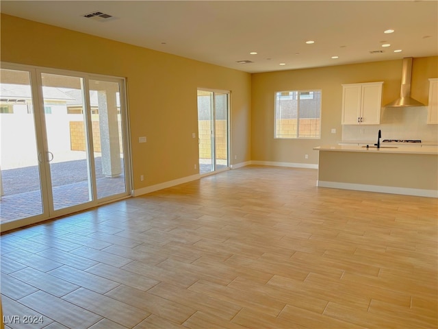 unfurnished living room with light hardwood / wood-style flooring and sink