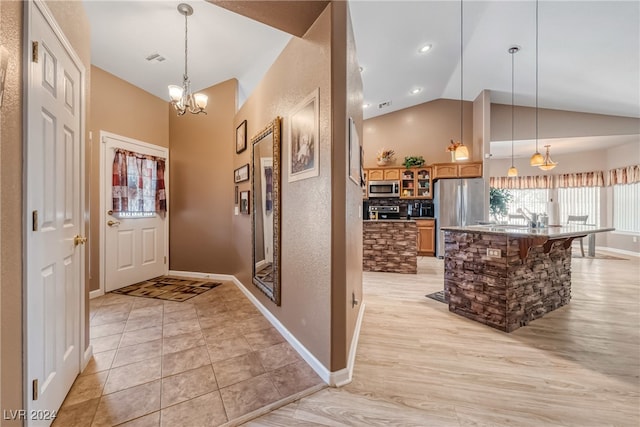 tiled entryway featuring lofted ceiling and an inviting chandelier