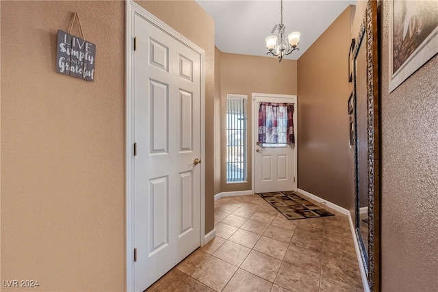 entryway featuring light tile patterned flooring and a notable chandelier