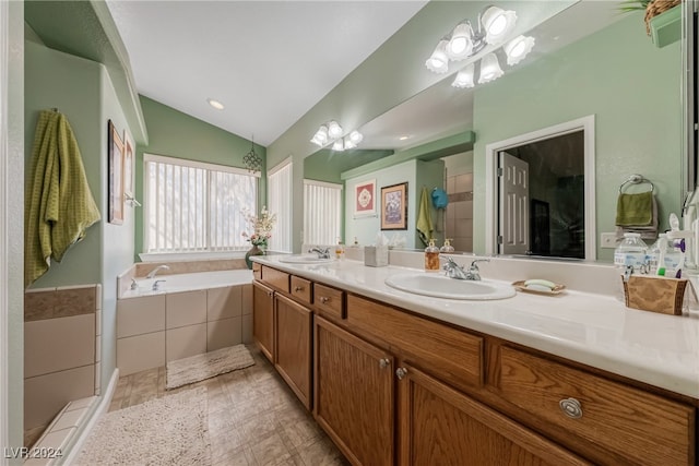 bathroom with vanity, shower with separate bathtub, and vaulted ceiling