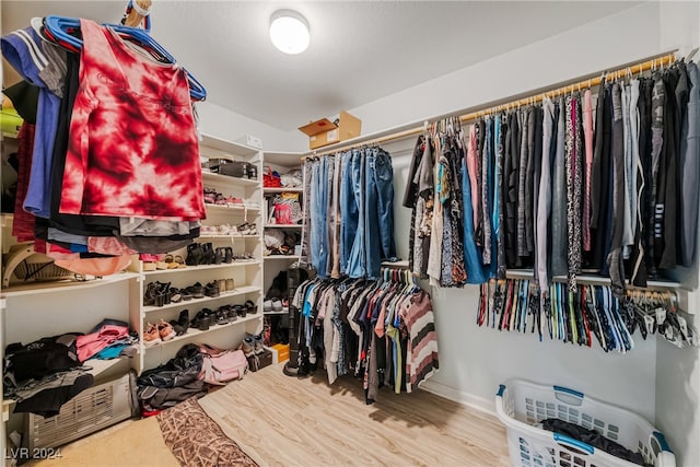 walk in closet with hardwood / wood-style flooring