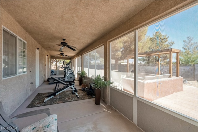 unfurnished sunroom with ceiling fan