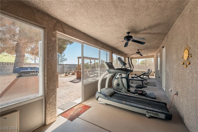 workout area with concrete floors and ceiling fan