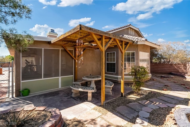 back of house featuring a sunroom, a pergola, and a patio