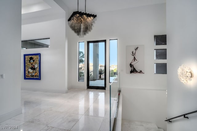 entryway with a towering ceiling and a chandelier