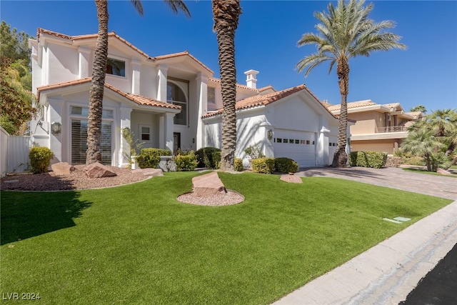 mediterranean / spanish house featuring a garage and a front lawn