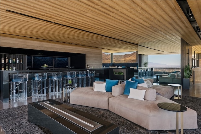 living room with wood ceiling and a wall of windows